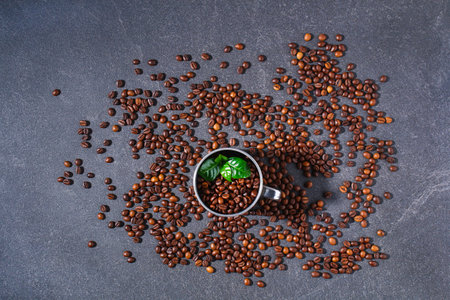 Roasted brown coffee beans on a gray background. Template for advertising coffee. Top view.