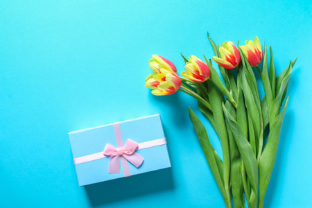 A bouquet of tulips as a gift for March 8, Mothers Day, Valentines Day. Easter decor. Top view. Flowers tulips on a blue background.の写真素材