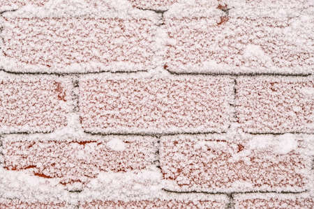 The brick wall is covered with snow patterns. Frost on the brick texture. Frosty frost, snow...