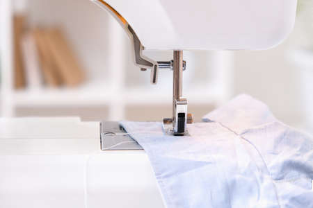 A man sews clothes on a sewing machine. Hobbies, needlework, creativity.の写真素材