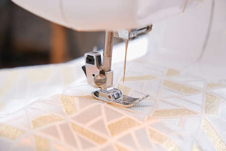 A man sews clothes on a sewing machine. Hobbies, needlework, creativity.の写真素材