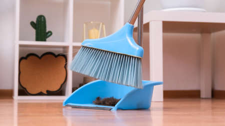 Hair after cutting on the floor. Cleaning hair with a broom in a dustpan.の写真素材