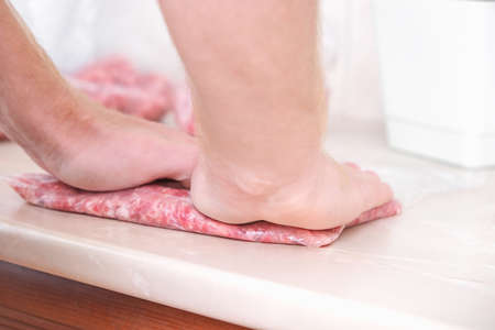 A man makes flat minced pork and beef in bags for storage in the freezer.の写真素材