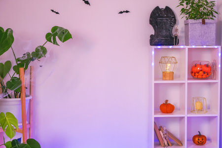 Space decorated for Halloween with toys such as bats, spiders, human skeleton, pumpkin, tombstone, books. Decoration the house for the Halloween holiday. Copy space. Free space. Neon light.の写真素材