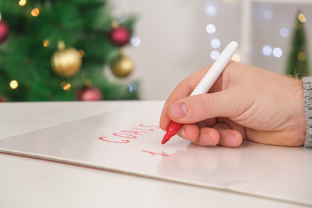 A man writes his goals and plans on a marker board for New Year and Christmas.の写真素材