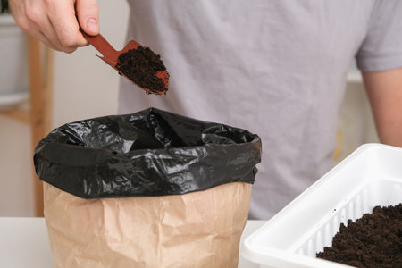 The man fills the balcony box with earth, universal soil. Preparation of seedlings. Growing...