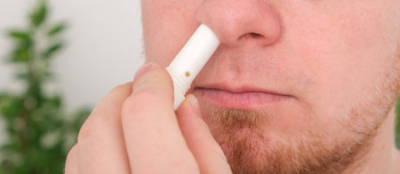 Adult man uses nasal stick inhaler to smell for relieve dizzy and faint symptoms. Concept health problem, sickness and remedy. Increases freshness, reduces dizziness and stuffy nose. self take care.の写真素材