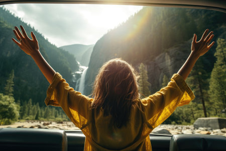 A woman rides in a car and enjoys the views of mountains and waterfalls. Auto travel. Car trip.の素材