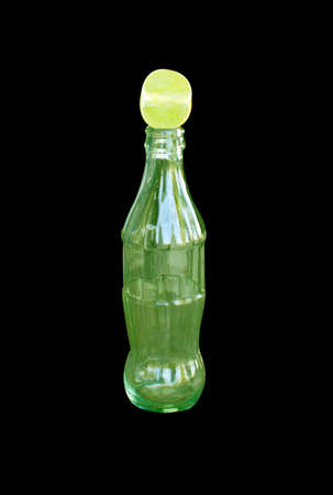 Lime glass and bottle on a black background.