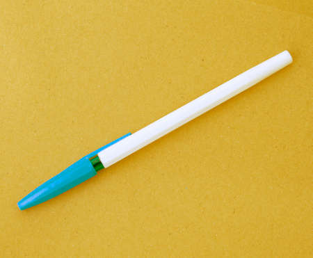 A writer's pen on a sheet of yellow paper.