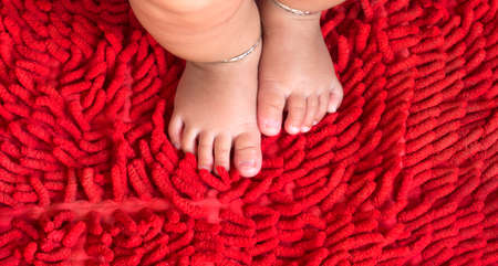 Baby feet on red carpetの写真素材