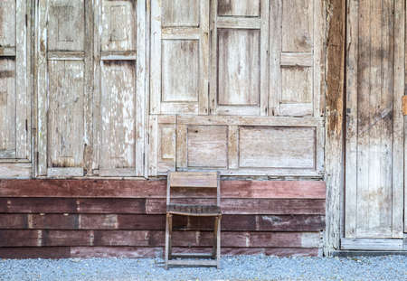 Old wooden wall and wooden chairの写真素材