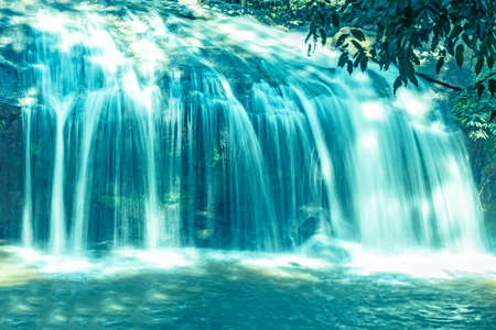 Beautiful blue water fall, vast nature, green trees and rocks.の写真素材