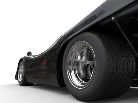 Shiny jet black vintage race car - rear wheel closeup shotの写真素材