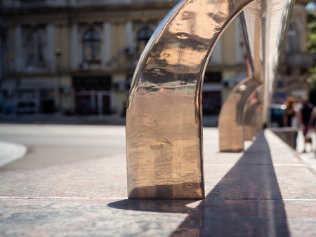 Chrome guard rail on a marble bench in the cityの写真素材