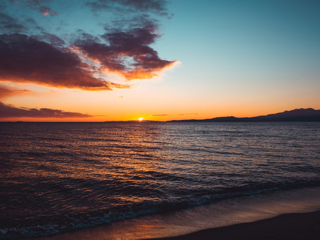 Sunset seen from the empty beach - mountains on the horizonの写真素材