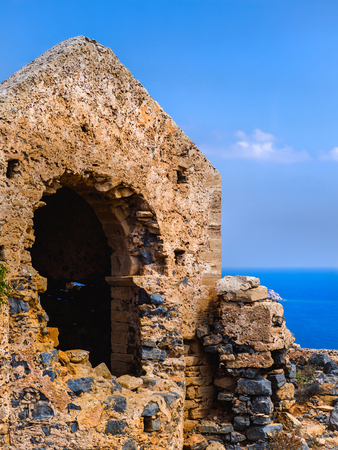 Ancient temple ruins atop the hill - sea and clear skies in the backgroundの写真素材