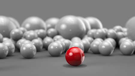 Red ball in focus with bunch of white balls behind it - red one stands outの写真素材