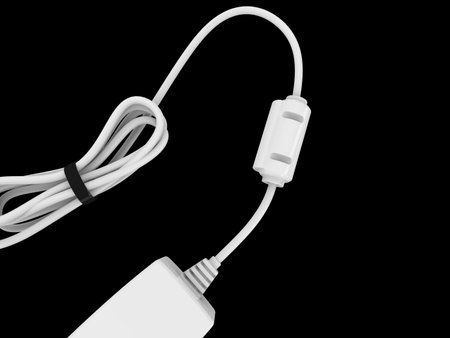 White cable bent and coiled up and held with black rubber band with electric adapter on the endの写真素材