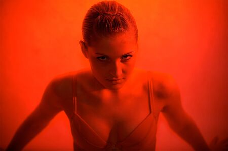 Young sexy woman portrait, red lightの写真素材
