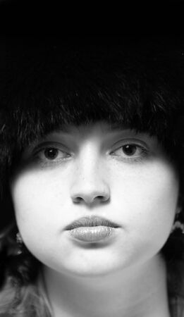 Black-n-white woman portrait in black fur-cap looking to cameraの写真素材