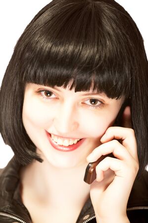 Young beautiful brunette talking to mobile phone with smile, isolatedの写真素材