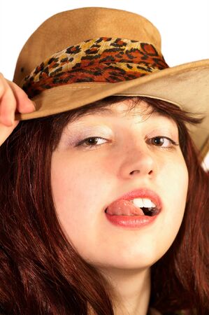 Young woman in hat shows tongue, isolatedの写真素材