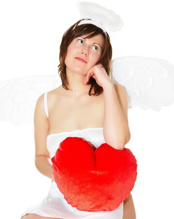 Young woman in angel's costume with red heart, isolated on whiteの写真素材