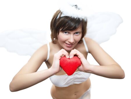 Young woman in angel's costume with red heart, isolated on whiteの写真素材