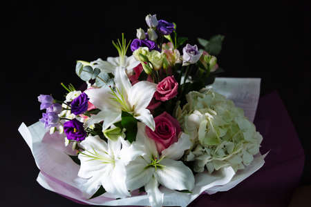 Bouquet of beautiful flowers on dark material background. Shallow depth of field and close-up.の写真素材