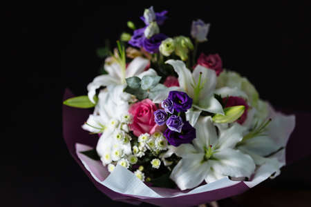 Bouquet of beautiful flowers on dark material background. Shallow depth of field and close-up.の写真素材
