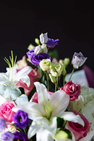 Bouquet of beautiful flowers on dark material background. Shallow depth of field and close-up.の写真素材