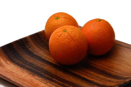Oranges on a beautiful wooden plate. Tropical fruits.の写真素材
