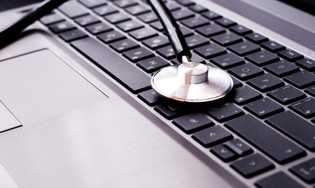 Stethoscope resting on a computer keyboard  concept for online medicine or IT support