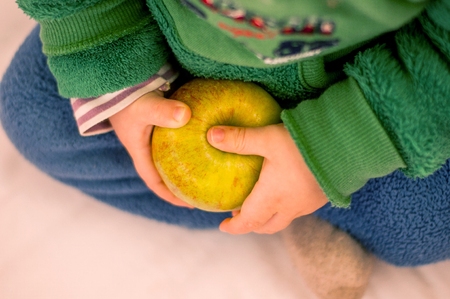 Child holding an apple in a hand.の写真素材