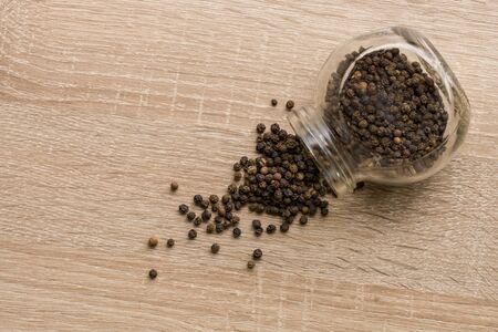 Black Pepper Peas Scattered On The Table From A Glass Jar. Close Up. Macro. Top View.の写真素材