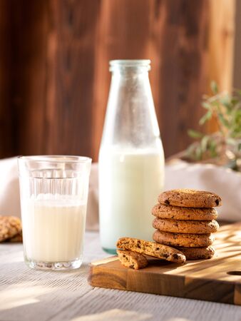 Oatmeal Cookies On A Wooden Board On A Sunny Day With A Glass And A Bottle Of Milk.の写真素材