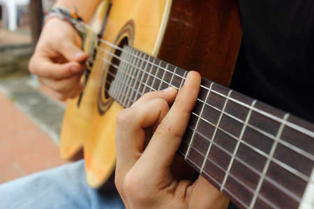 Hand and guitar of a player diffusing sound