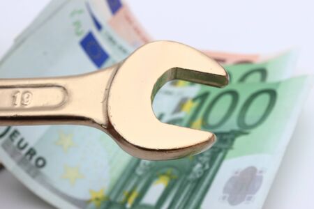 Gold wrench tool and Euro: the rising cost of laborの写真素材