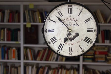 clock in a library with shelf on background