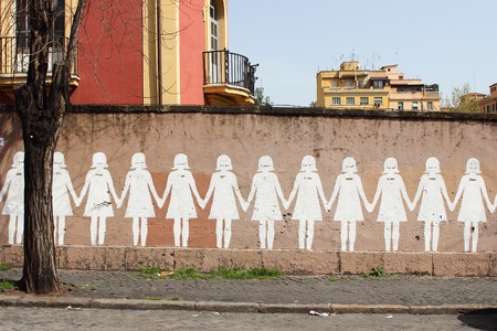 line of white dolls painted in a wallのeditorial素材
