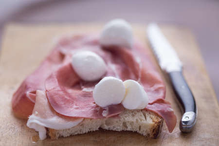 Chopping board with ham and mozzarellaの写真素材