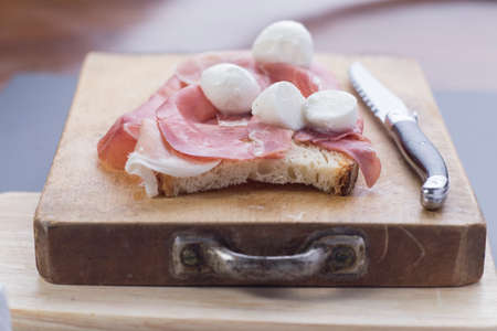 Chopping board with ham and mozzarellaの写真素材