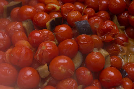 Boiling pachino variety tomatoes with eggplantsの写真素材