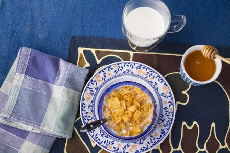 Morning breakfast with milk, corn flakes and honeyの写真素材