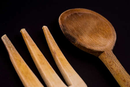 wooden cutlery isolated on blackの写真素材