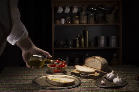 Hand pouring oil on bruschettaの写真素材