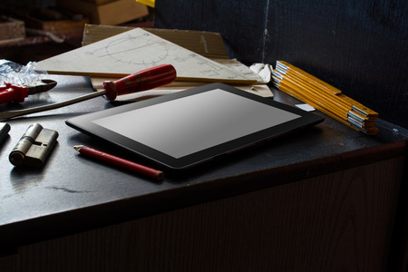 Tablet With Blank Screen On A Dark Cupboard With Tools In A Dirty Basement