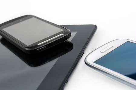 Black Smartphone On Black Tablet With White Mobile Besides