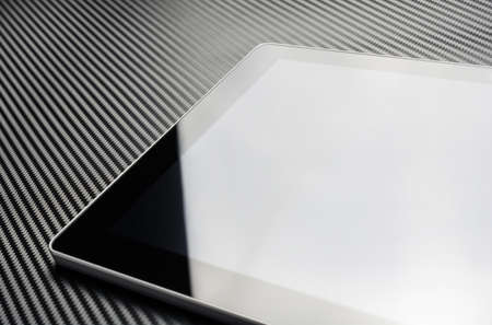 Blank Business Tablet With Reflection Lying On Carbon Layerの写真素材